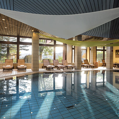 Bright indoor pool with loungers and garden view at the Maritim Hotel Titisee