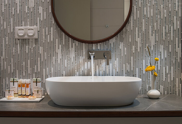 Modern washbasin with round mirror and premium toiletries at Maritim Hotel Amelia