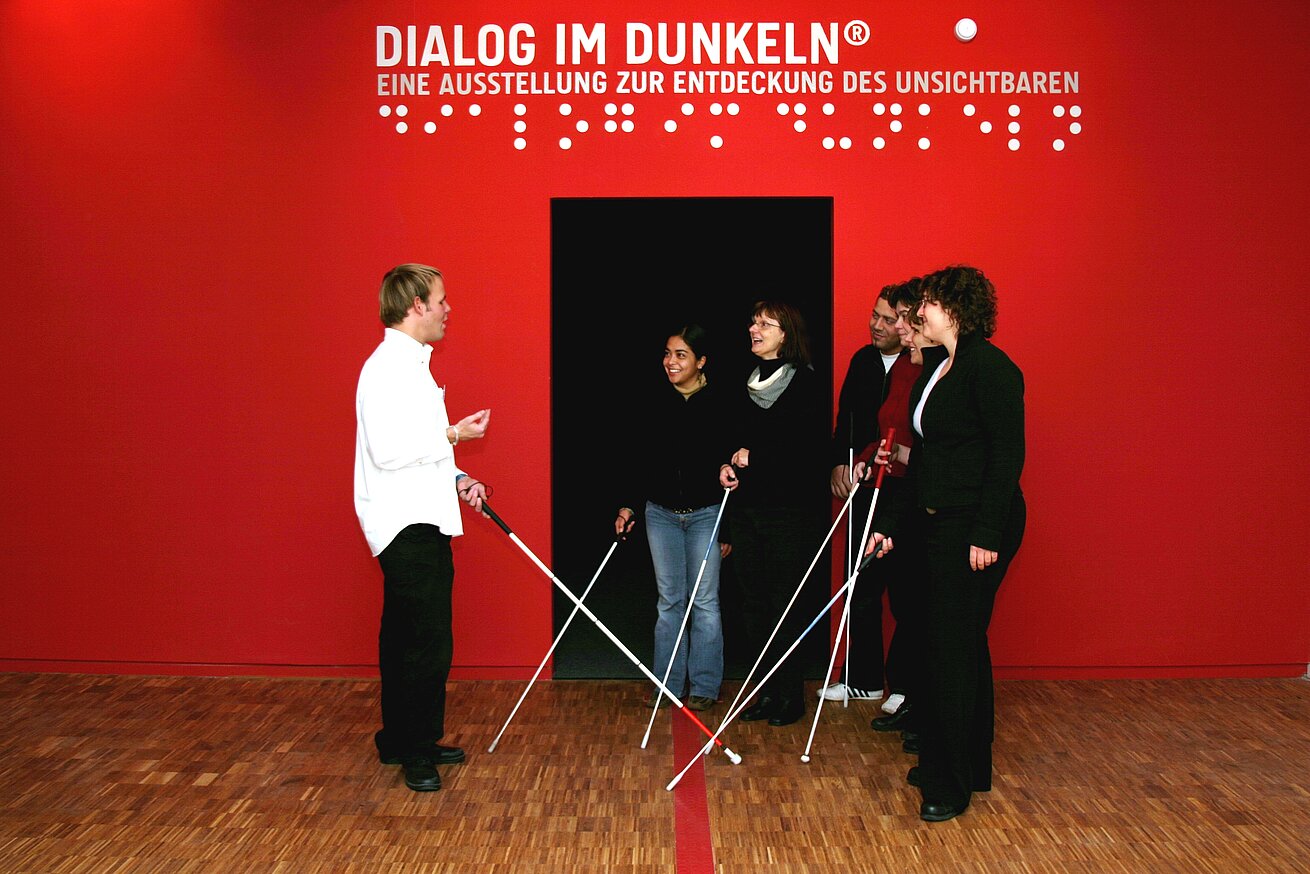 Group with white canes at the Dialog im Dunkeln exhibition in Bonn