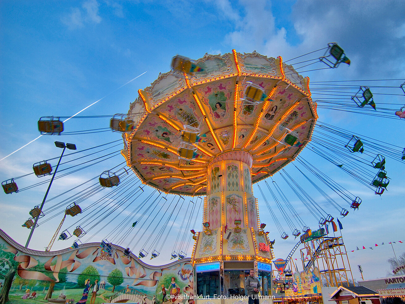 Illuminated swing carousel at a fair during evening twilight