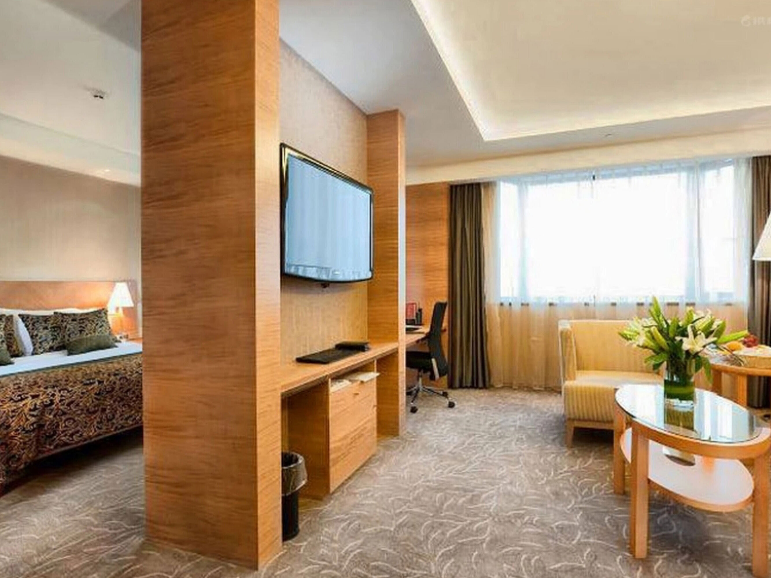 寬敞套房設有獨立臥室與起居區，配備舒適沙發、書桌及大面積窗戶，為您打造舒適住宿體驗