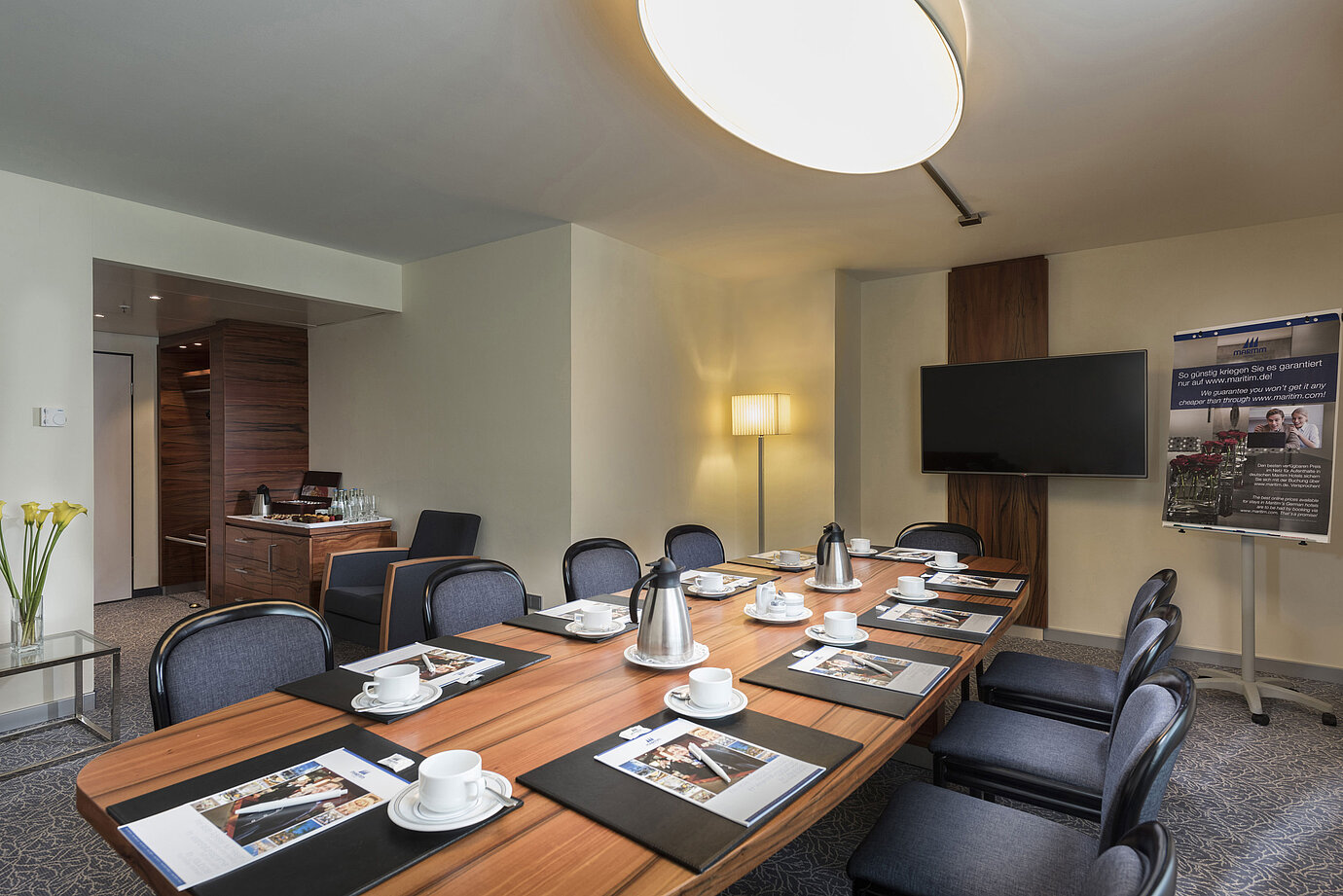 Meeting room with wooden table, chairs and presentation setup at the Maritim Hotel Munich