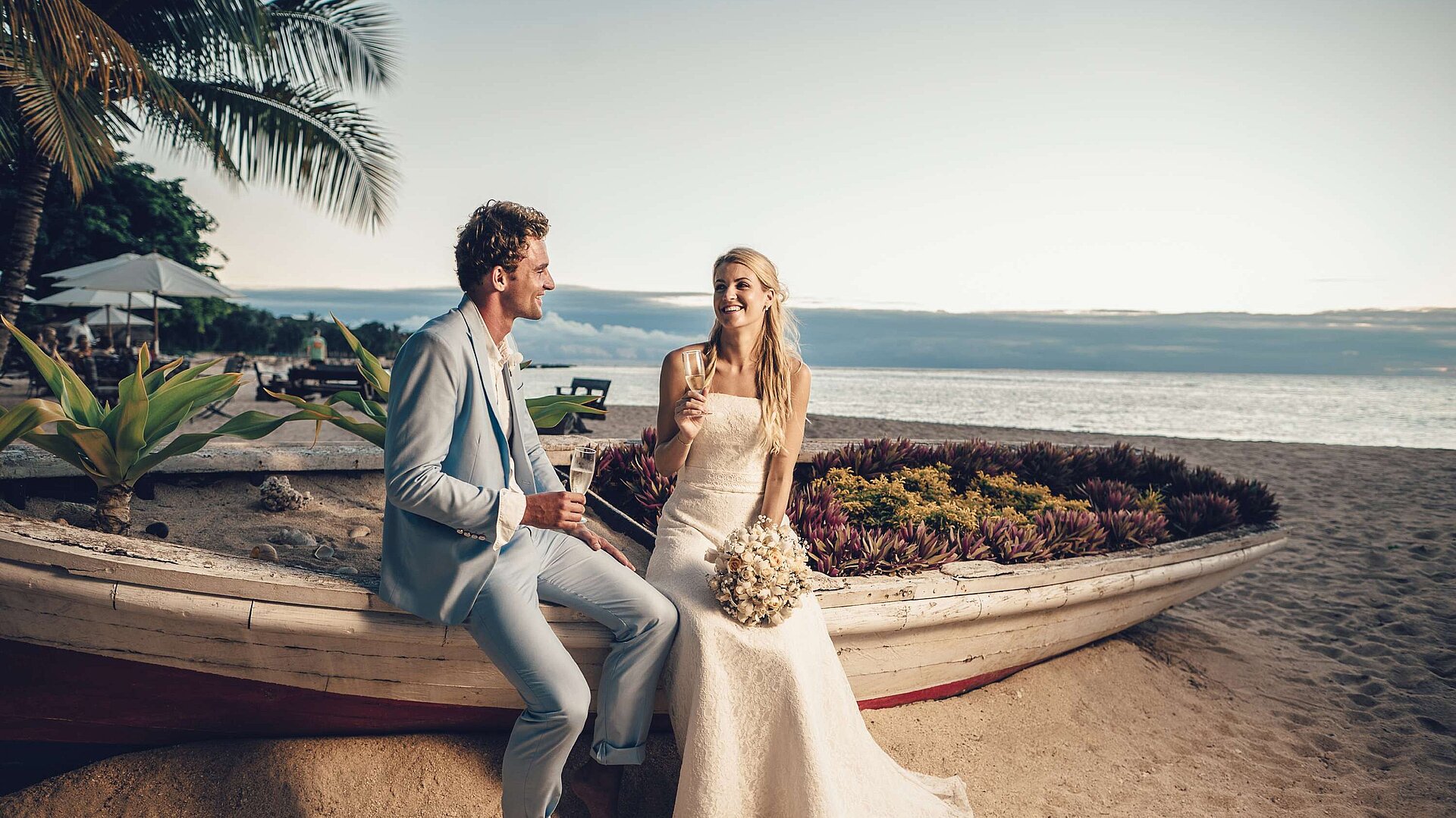 Wedding couple toasting with champagne on the beach during a romantic seaside wedding