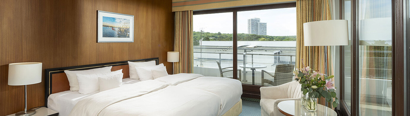 Spacious family suite at Maritim Seehotel Timmendorfer Strand with balcony, sea view, and cozy seating area.
