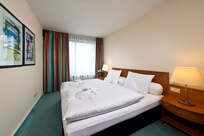 Bedroom of the master suite at Maritim Hotel Frankfurt with double bed, modern furnishings, and relaxing ambiance.