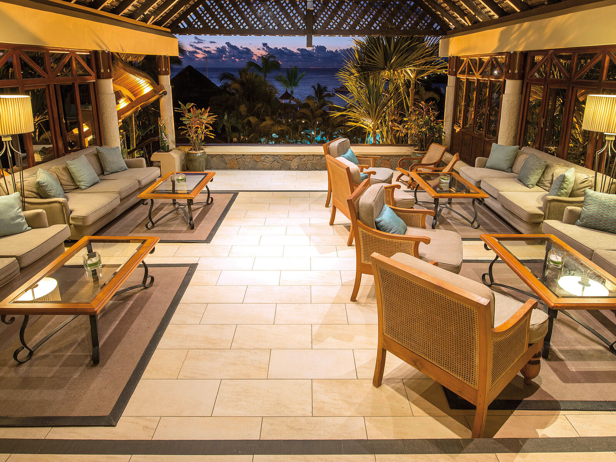 Elegant hotel lounge with sofas, armchairs and sea views in atmospheric evening light