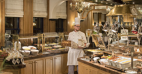 Breakfast buffet at the "Rôtisserie" restaurant in Maritim Hotel Bonn with a variety of dishes and a friendly chef.