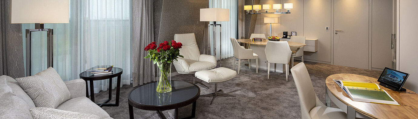 Premium suite with elegant interior, seating area, dining table, and sophisticated decor.