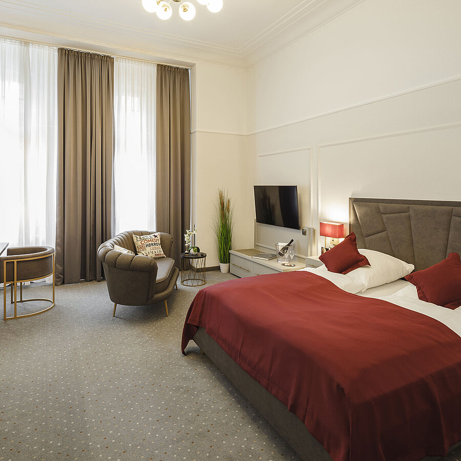 Spacious double room with seating area, TV and daylight at Hansa Hotel Wiesbaden