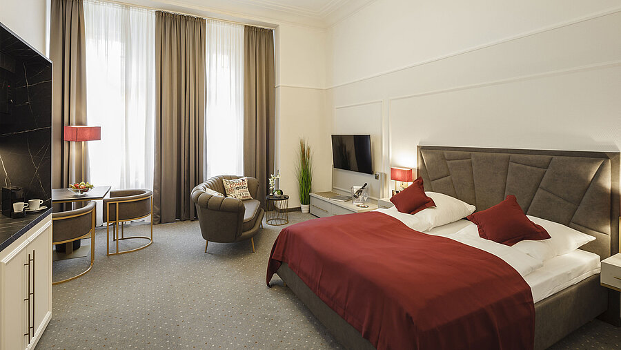 Spacious double room with seating area, TV and daylight at Hansa Hotel Wiesbaden