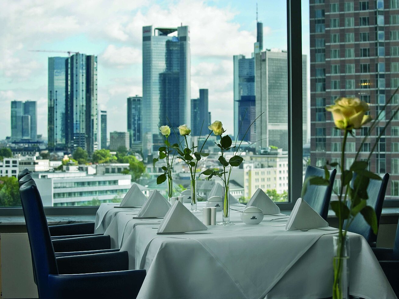 Elegant dining room with skyline view and set table in the SkyLounge at the Maritim Hotel Frankfurt.