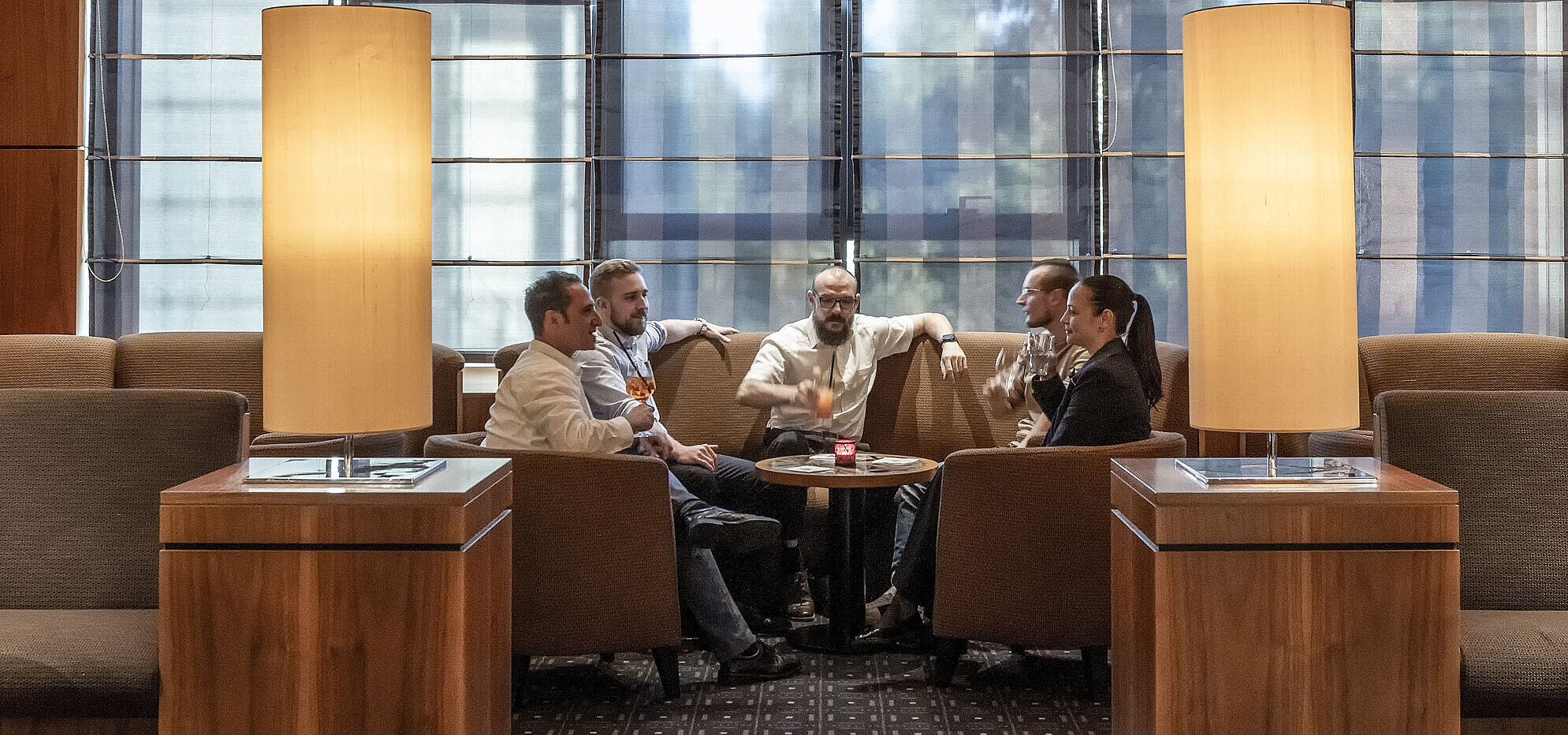 Cozy seating areas in the hotel bar at Maritim Hotel Düsseldorf with modern lighting and guests chatting.