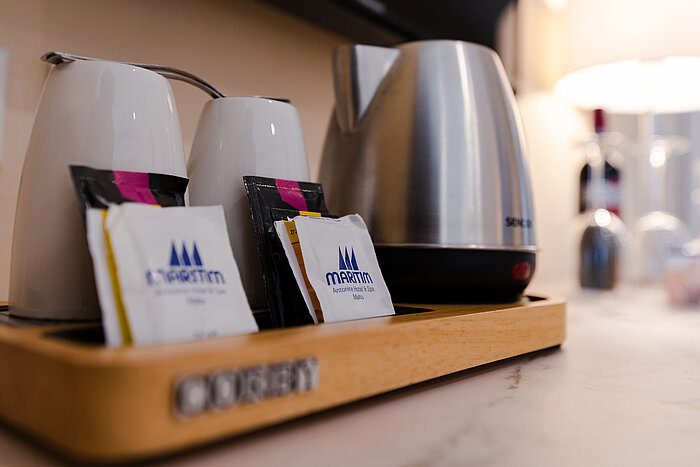 Coffee and tea station with kettle, cups and selection of tea and coffee in the hotel room