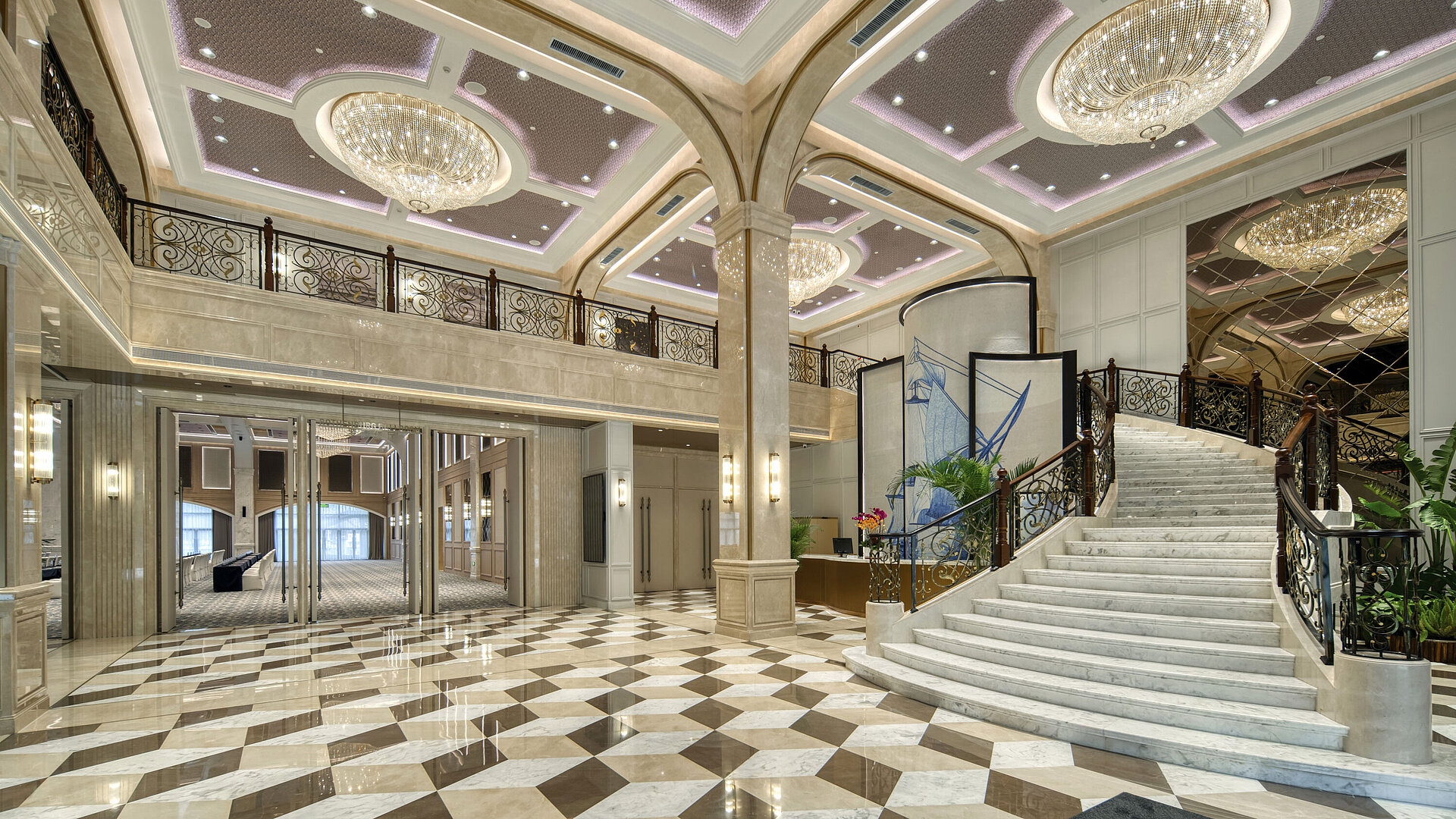 Spacious hotel lobby with marble flooring, opulent chandeliers and curved staircase at Maritim Hotel Taicang