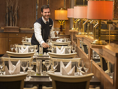 Waiter with tray of glasses in the restaurant at Maritim Hotel Stuttgart, friendly and welcoming