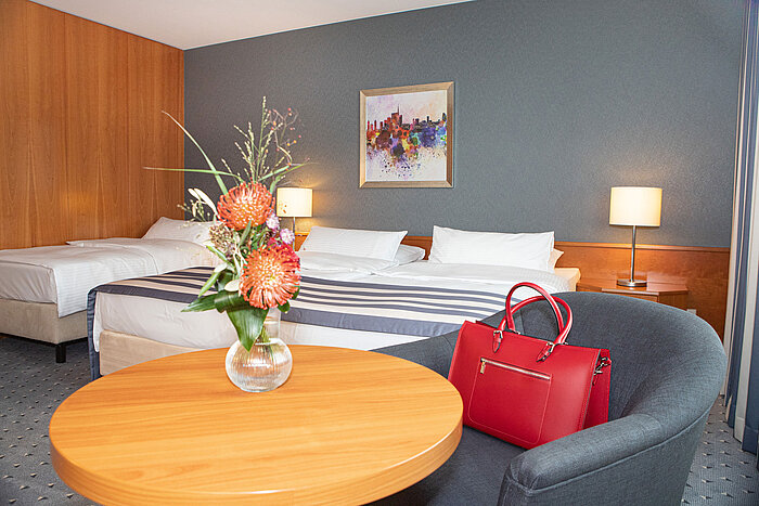 Spacious family room at Maritim Hotel Ulm with modern facilities and desk.