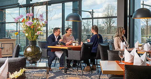 Wintergarten Restaurant Guests enjoying a meal in the restaurant at Maritim Hotel Dresden with outdoor views.