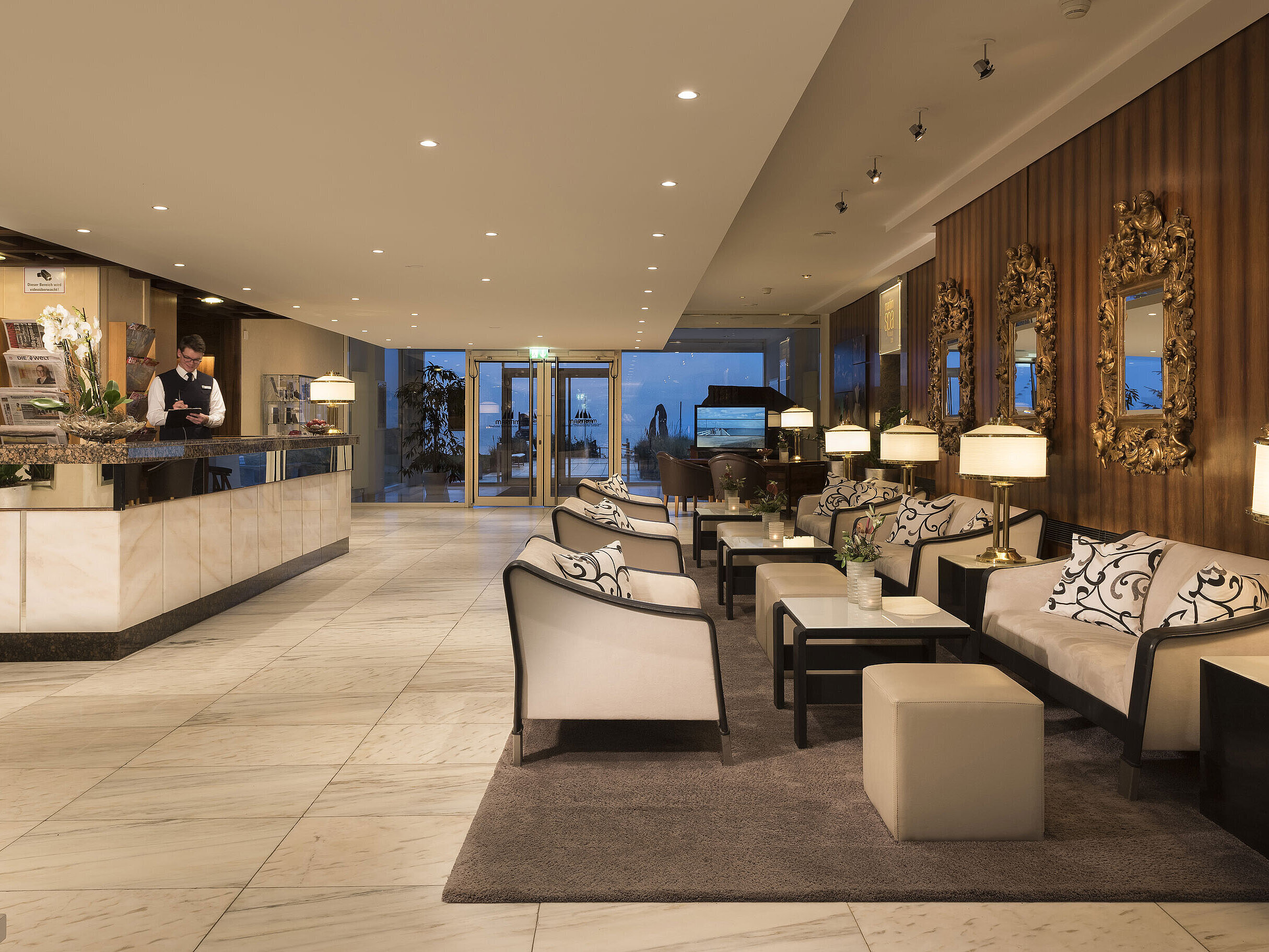 Reception and lobby with seating area at Maritim Seehotel Timmendorfer Strand during evening lighting.