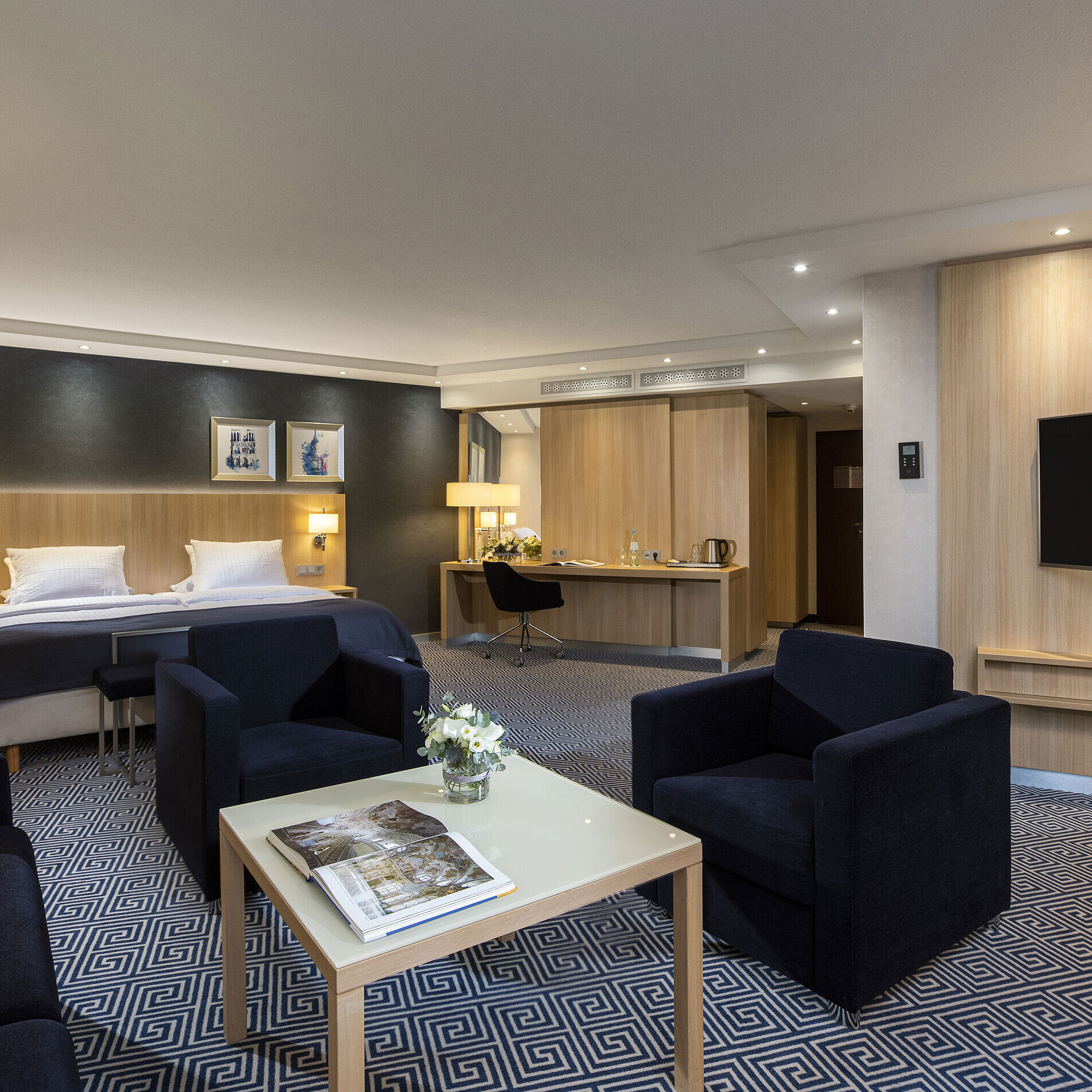 Spacious Junior Suite at Maritim Hotel Würzburg with a double bed and cozy seating area