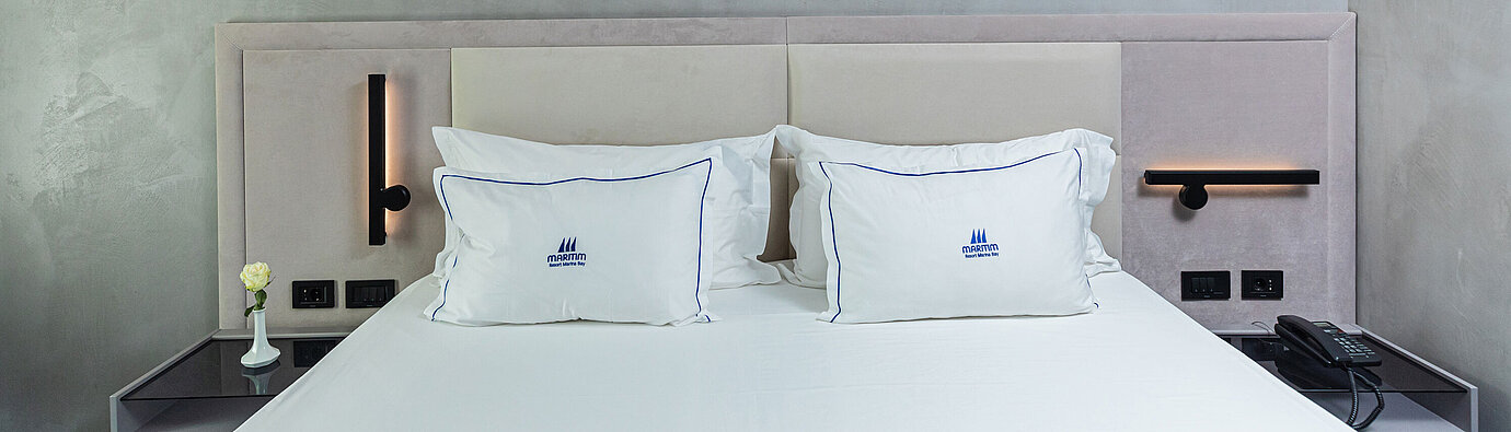 Modern double bed at Maritim Resort Marina Bay with stylish headboard and pillows