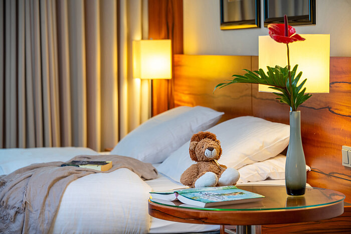 Cosy family room with plush toy and modern décor at the Maritim Hotel München.