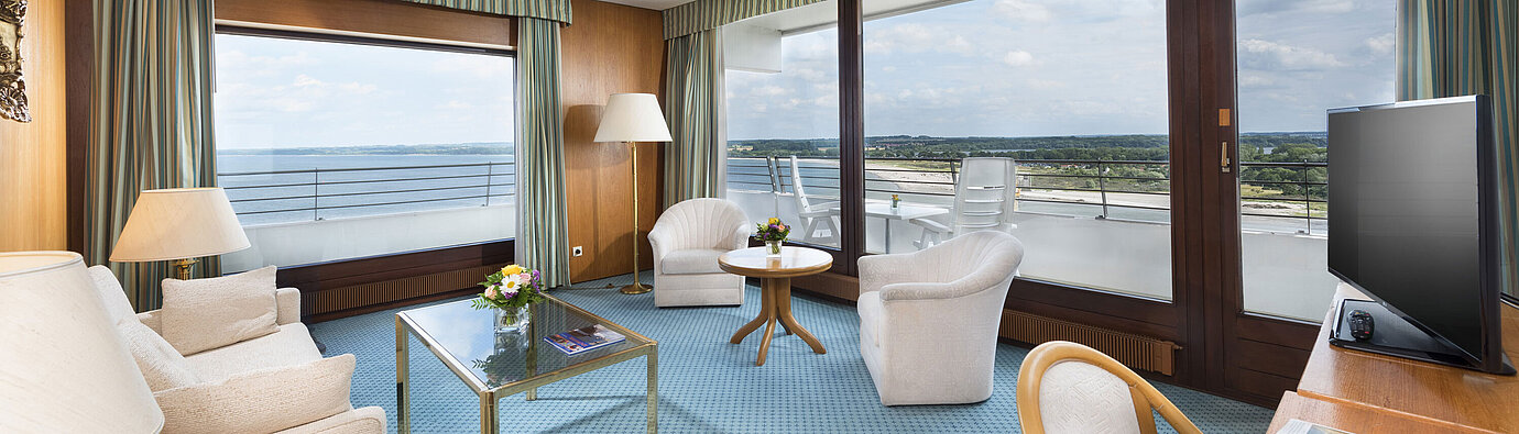 Spacious living area in the suite at Maritim Hotel Travemünde with panoramic view of the Baltic Sea