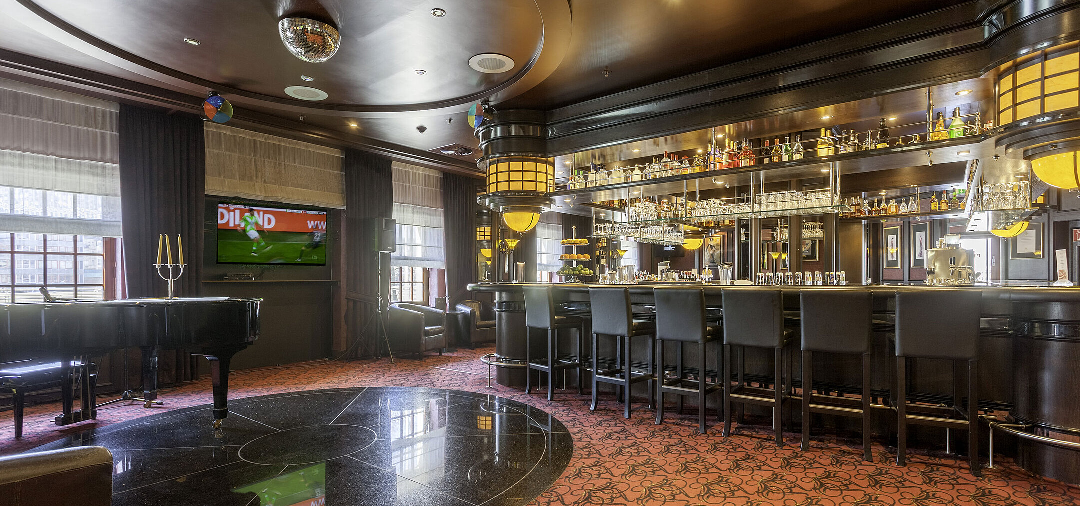 Stylish piano bar at Maritim Hotel Dresden with cozy ambiance, piano, and well-stocked bar.
