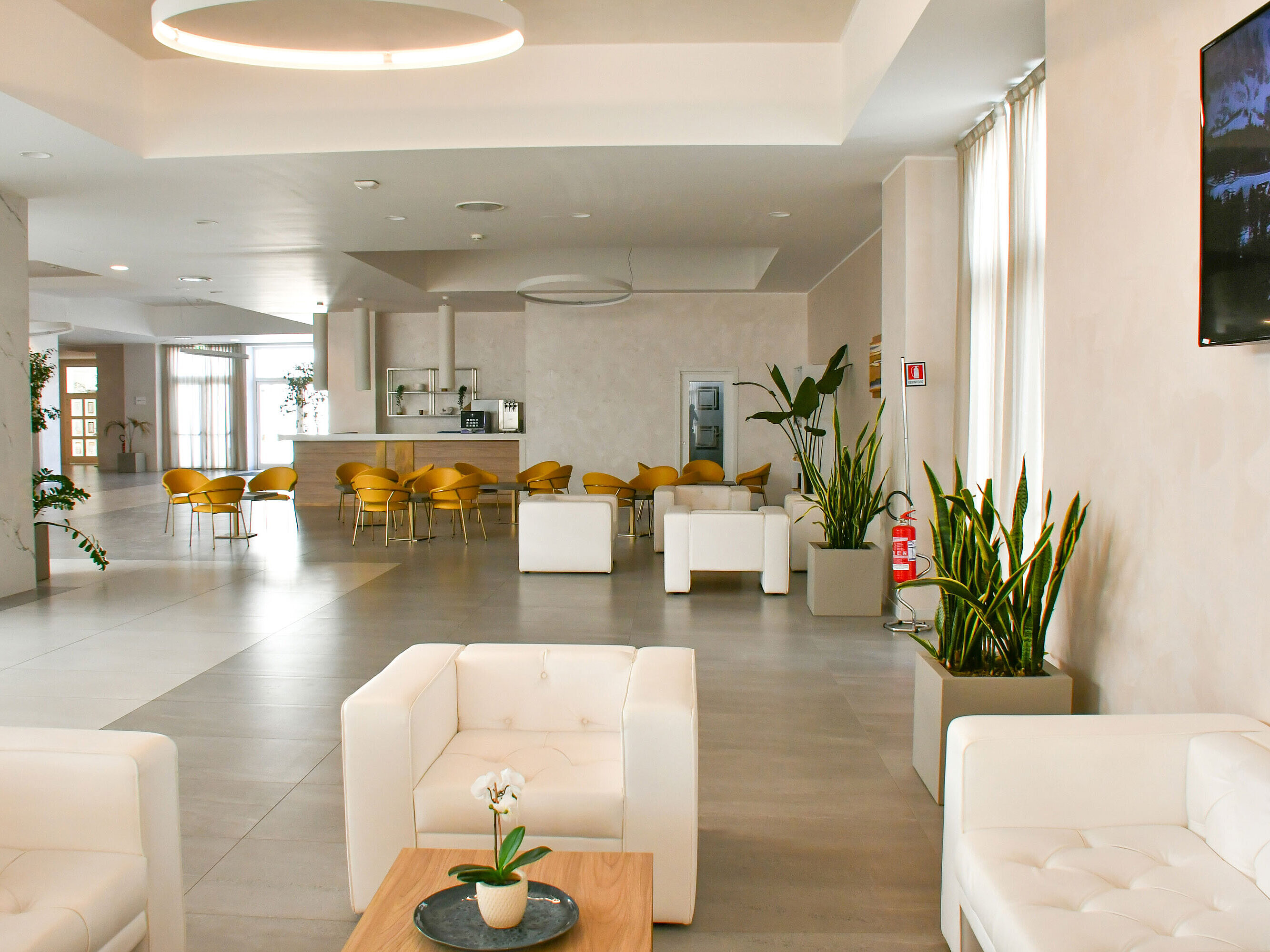 Bright lobby of Maritim Resort Calabria with white armchairs and yellow chairs
