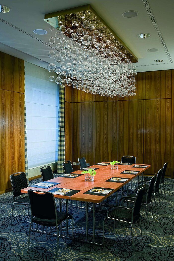 Exclusive meeting room at Maritim Hotel Düsseldorf with an elegant table, modern facilities, and unique chandelier.