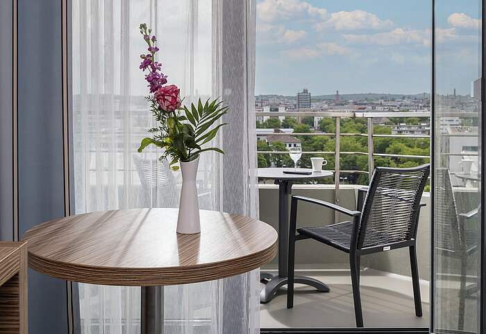 View from the Superior Room onto the furnished balcony with a wide view over the city of Darmstadt