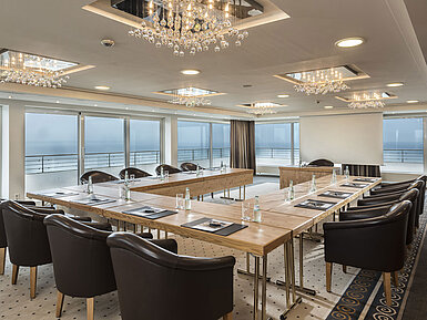 Salon Hamburg at Maritim Seehotel Timmendorfer Strand, conference room with sea view, L-shaped table, and elegant lighting.