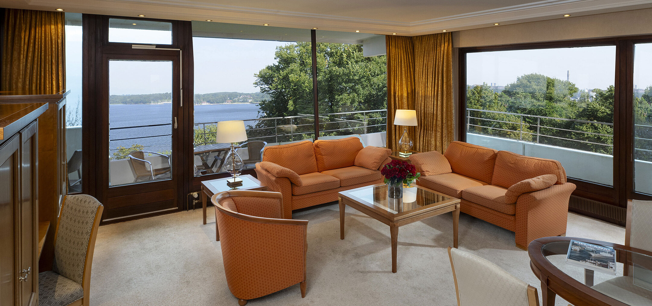 Bright living area of the presidential suite at Maritim Hotel Kiel with panoramic Baltic Sea view and stylish furniture.