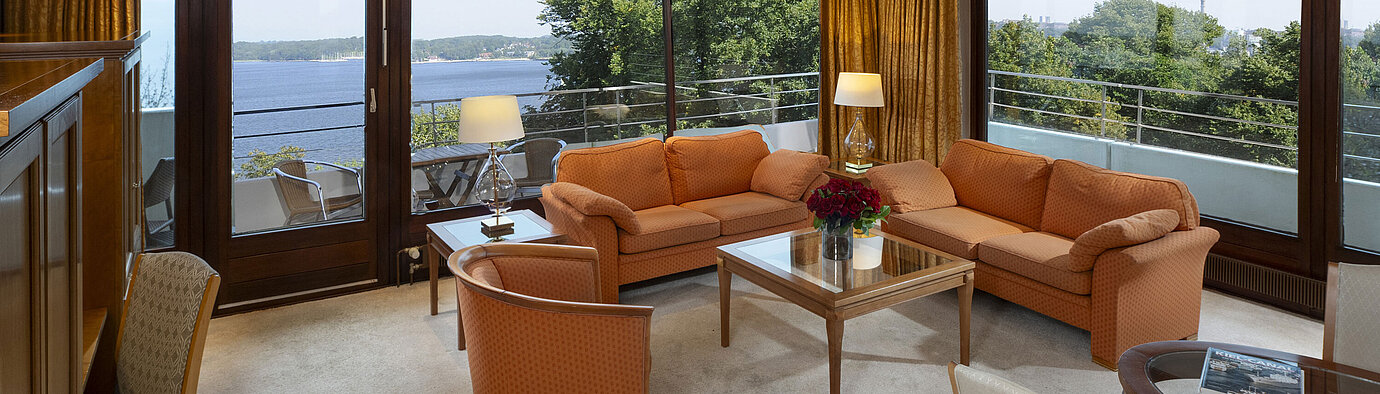 Bright living area of the presidential suite at Maritim Hotel Kiel with panoramic Baltic Sea view and stylish furniture.