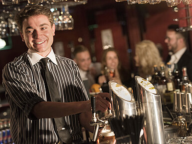 Friendly bartender serving drinks at the stylish bar of Maritim Hotel Frankfurt.
