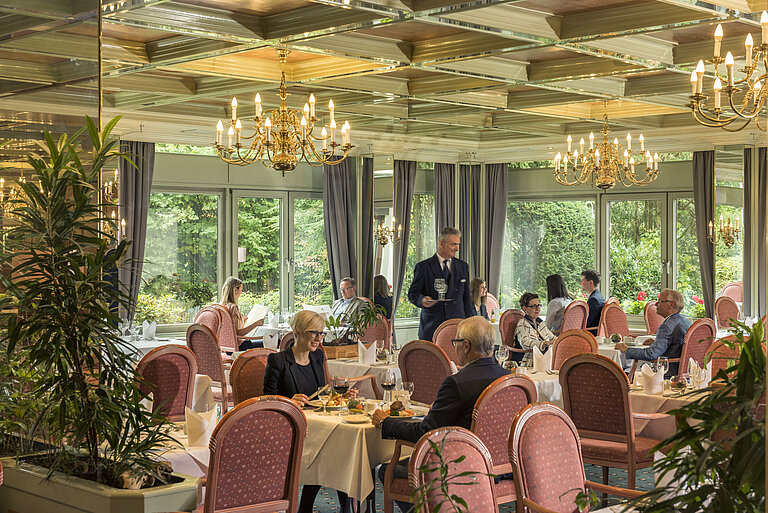 Spacious restaurant at Maritim Hotel Bad Salzuflen with chandeliers, large windows and elegant atmosphere