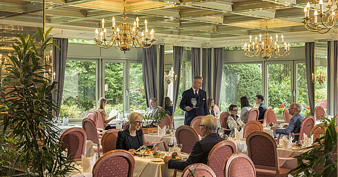 Spacious restaurant at Maritim Hotel Bad Salzuflen with chandeliers, large windows and elegant atmosphere