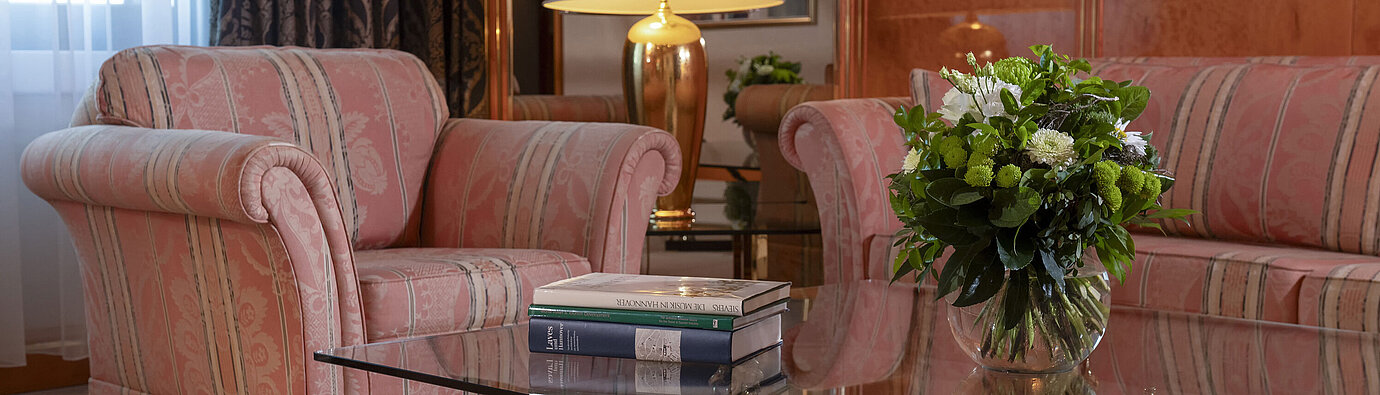 Stylish living room at Maritim Hotel Hannover with elegant seating area and glass coffee table.