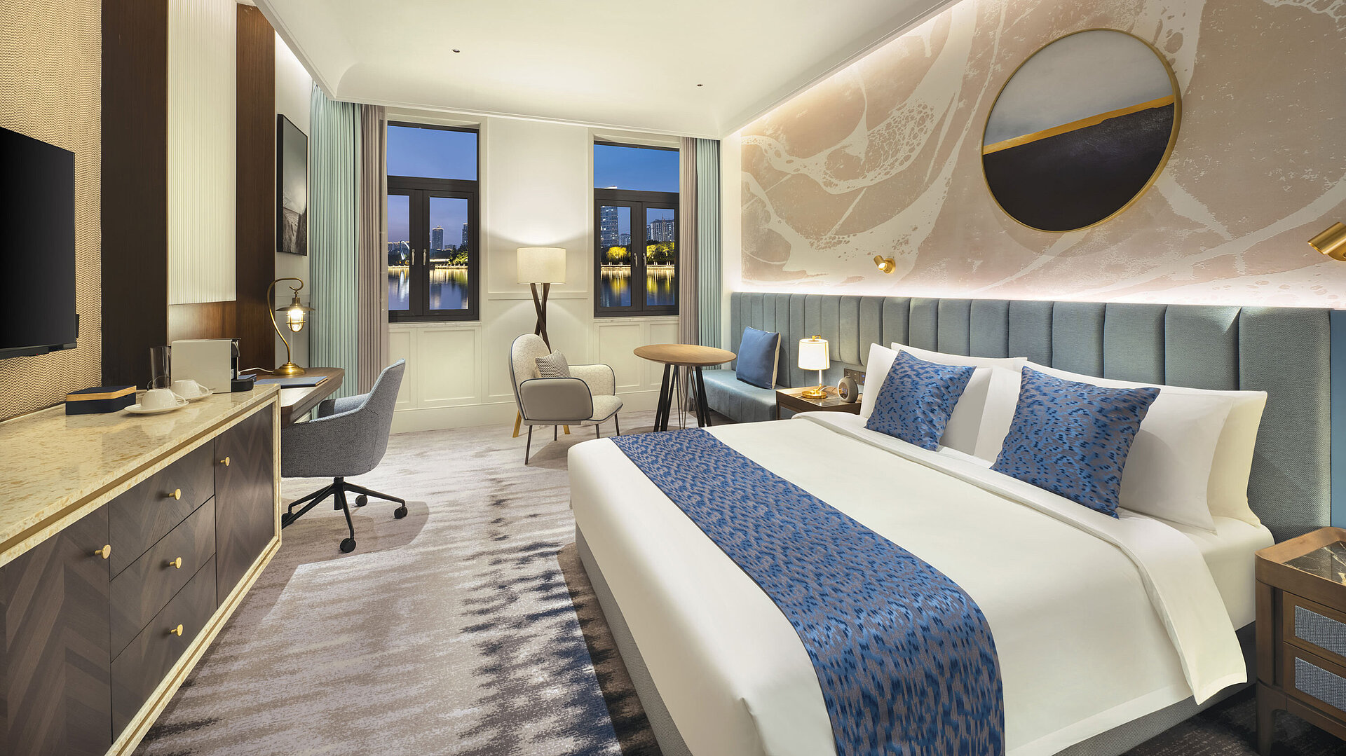 Spacious hotel room with modern design, cosy seating area and lake view at Maritim Hotel Taicang