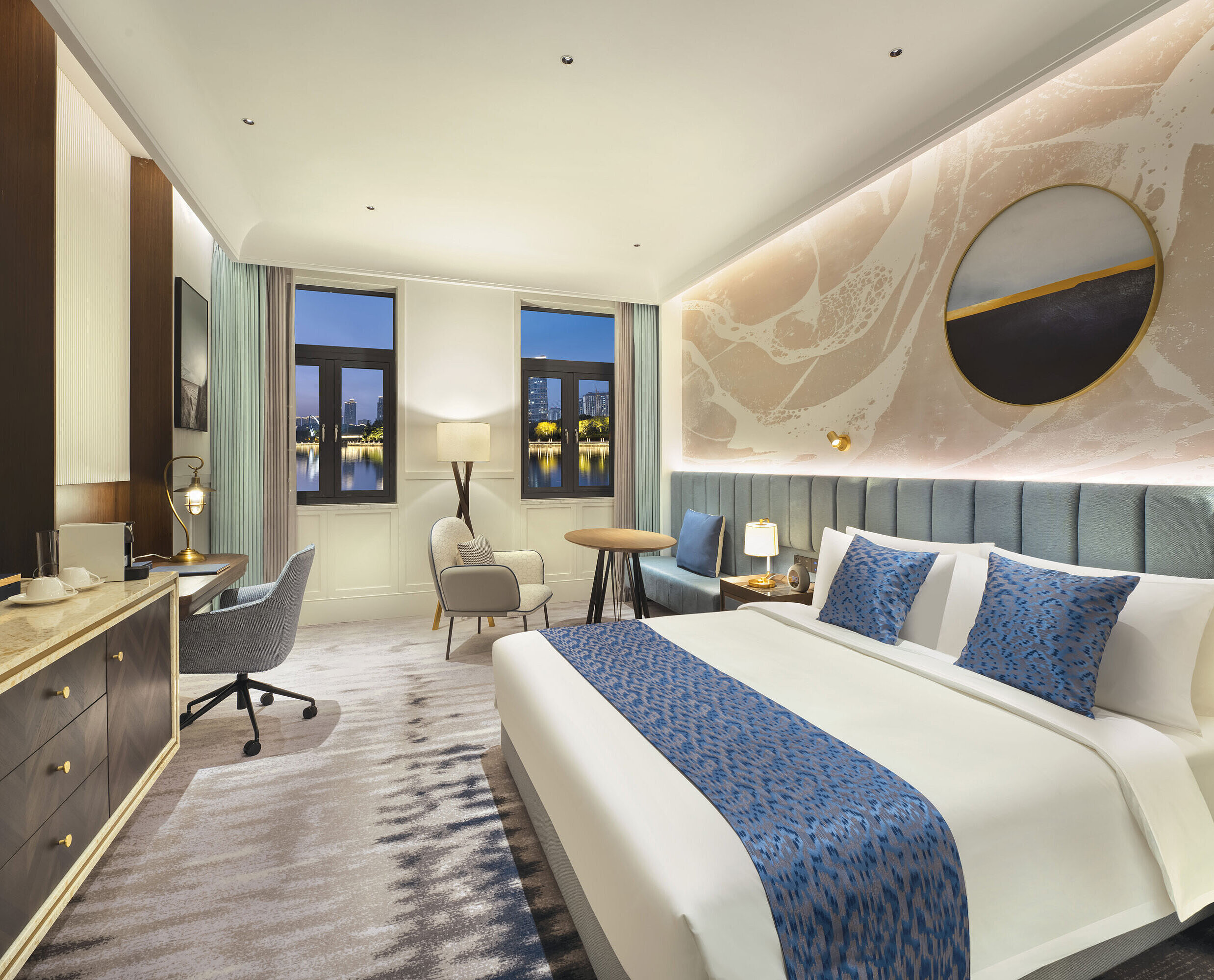 Spacious hotel room with modern design, cosy seating area and lake view at Maritim Hotel Taicang