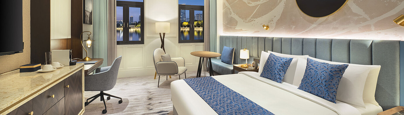 Spacious hotel room with modern design, cosy seating area and lake view at Maritim Hotel Taicang