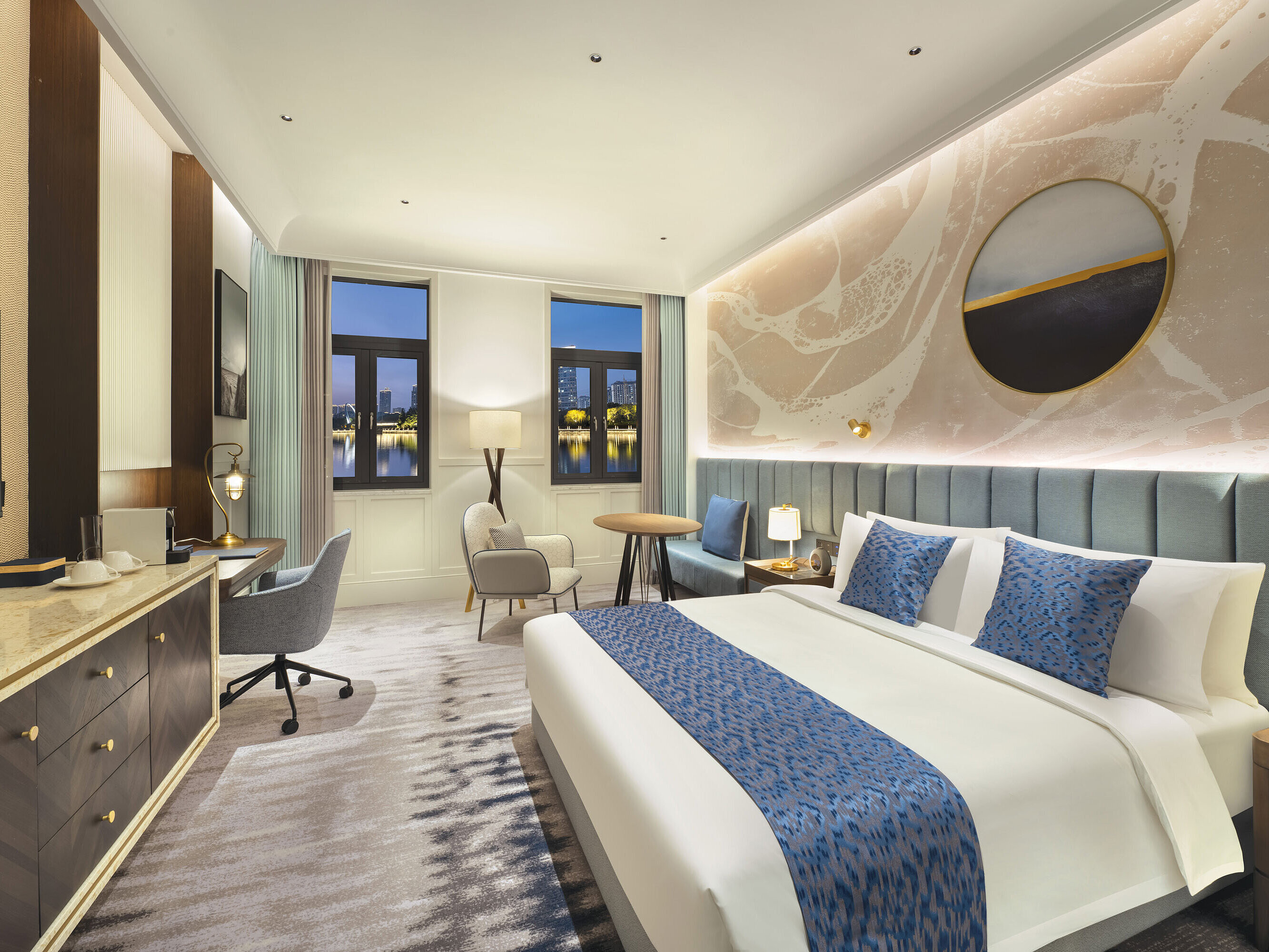 Spacious hotel room with modern design, cosy seating area and lake view at Maritim Hotel Taicang