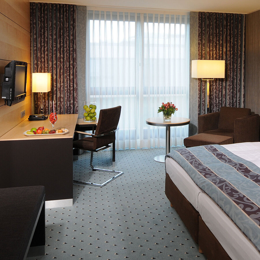 Superior room at Maritim Hotel Düsseldorf with stylish double bed, modern desk, cozy seating area, and fresh details.