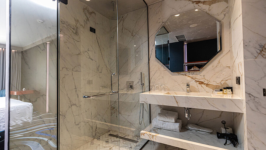 Luxury bathroom at Maritim Resort Marina Bay with marble tiles, shower and mirror