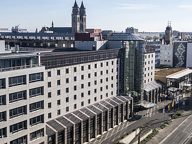 Exterior view of the Maritim Hotel with modern facade and central location, surrounded by historic buildings and city views.
