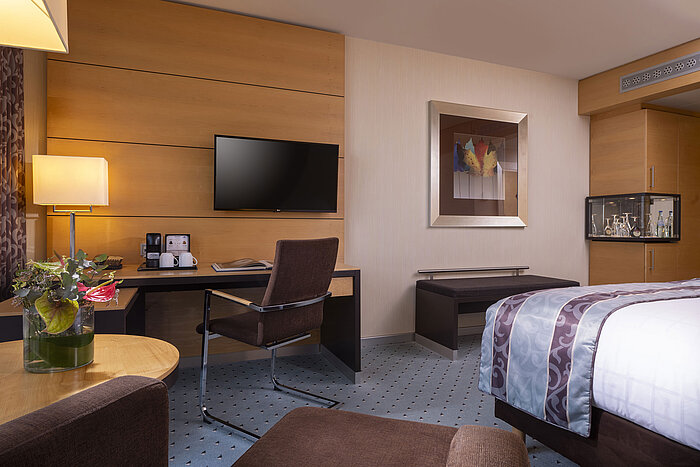 Elegant superior room at Maritim Hotel Düsseldorf with modern desk, TV, and stylish decor.