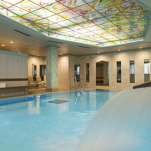 Heated indoor pool with waterfall and colourful glass ceiling at the Maritim Hotel Stuttgart