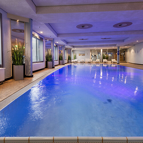 Illuminated indoor pool at Maritim Hotel Frankfurt with a relaxing atmosphere and panoramic windows.