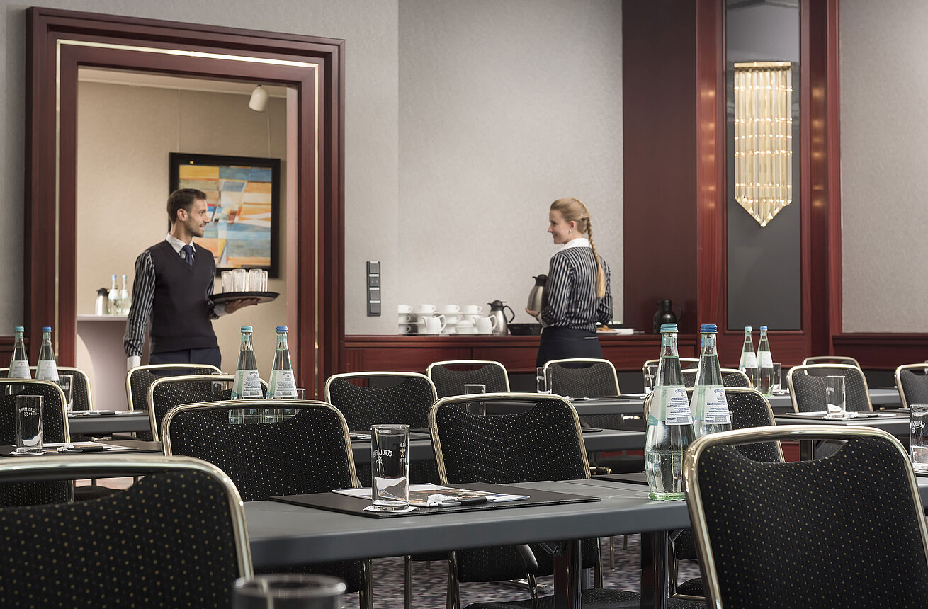 Elegant conference room at Maritim Hotel Hannover with friendly service, water bottles, and stylish seating.