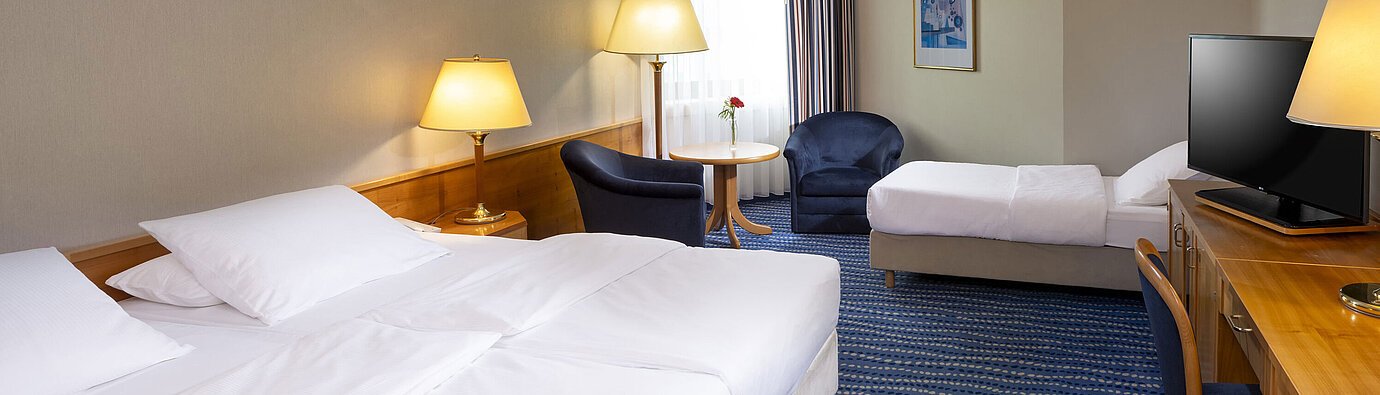 Classic family room with two beds, desk, flat-screen TV