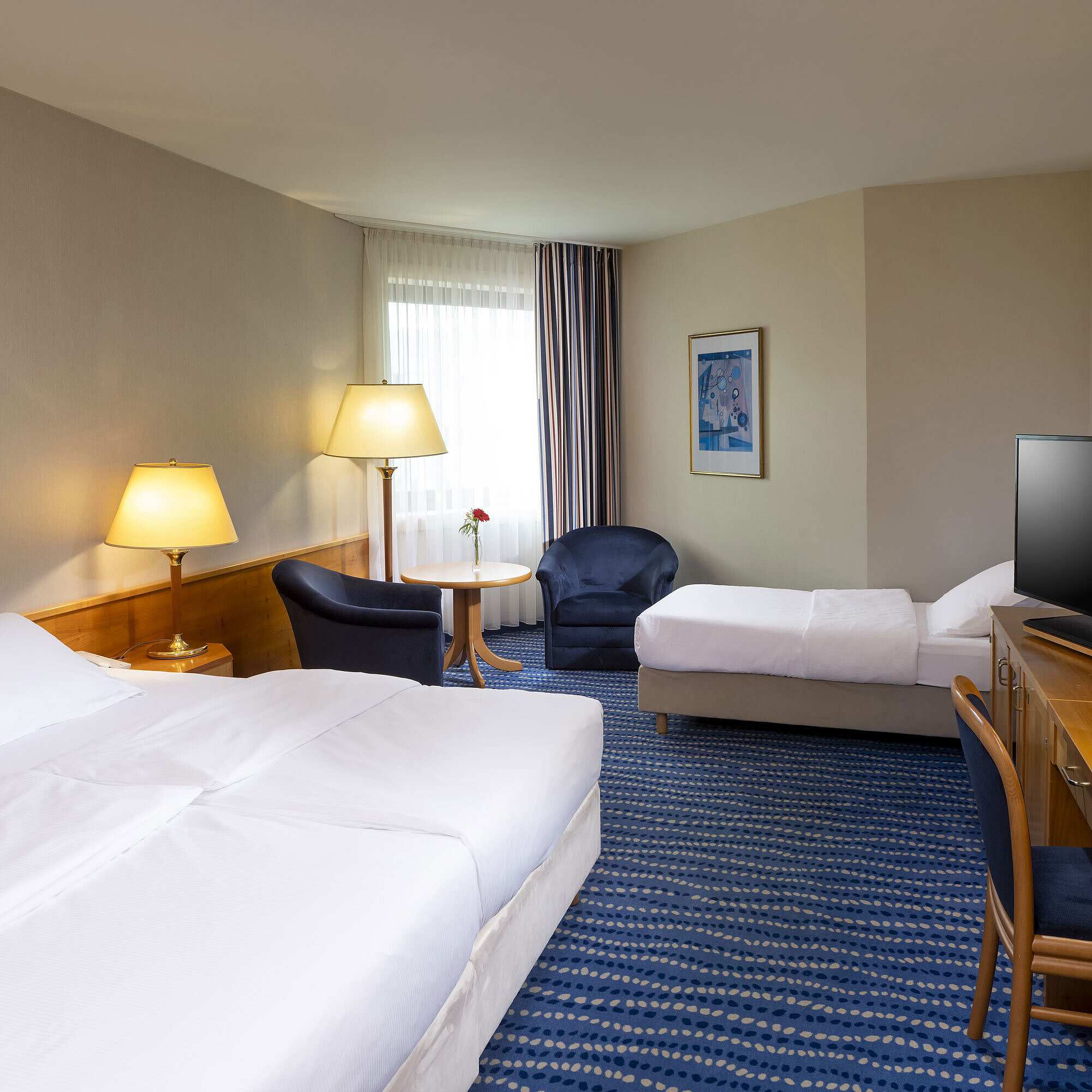 Classic family room with two beds, desk, flat-screen TV